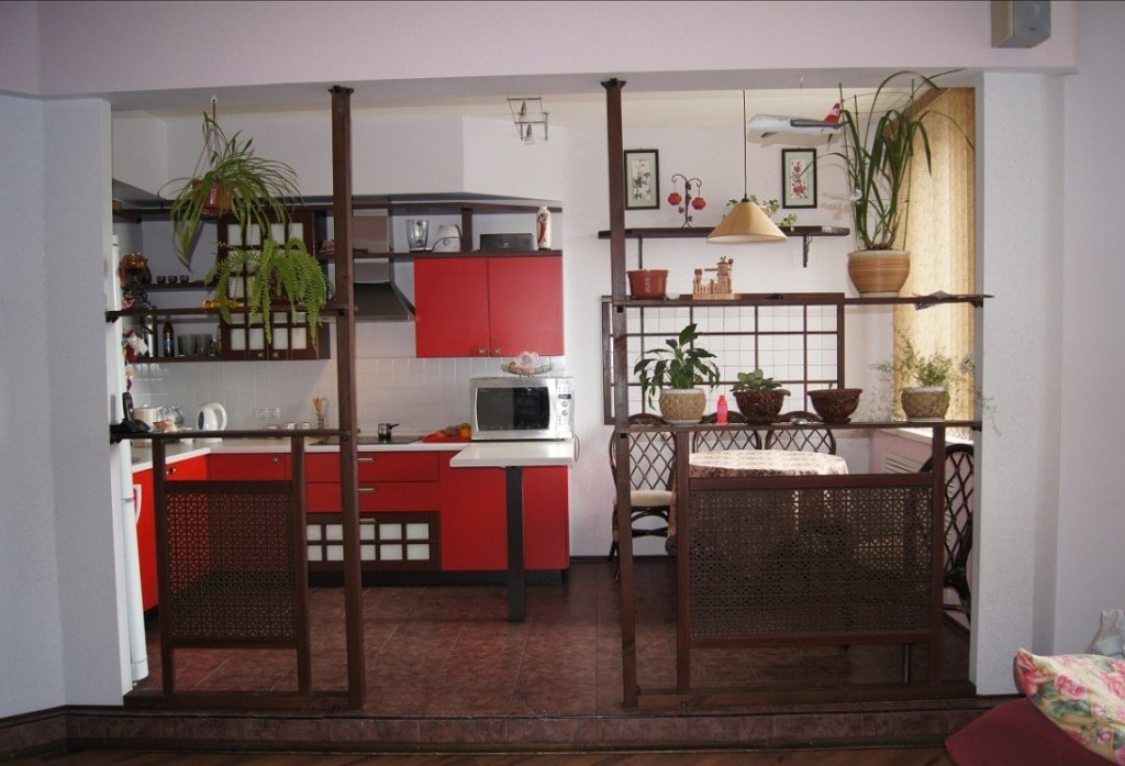 Об'єднати кухню з вітальні можна за допомогою дерев'яних перегородок і розсувних дверей