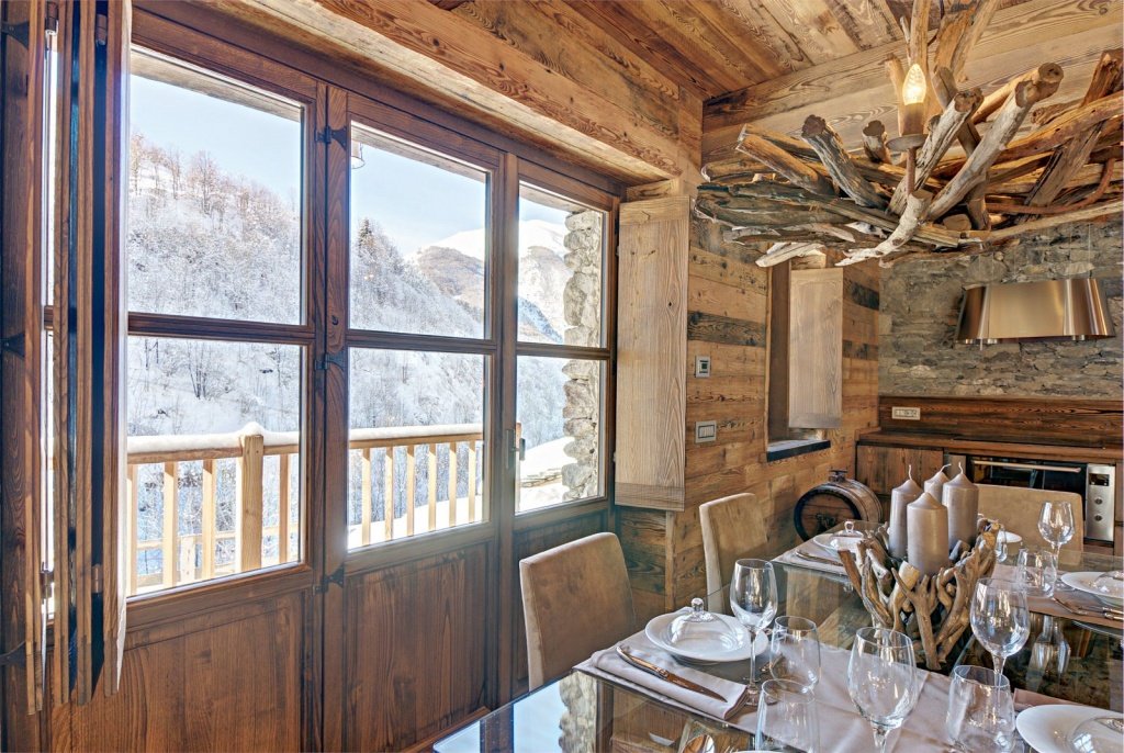 Прекрасный вид на снежные горы из окна традиционной кухни в альпийской деревне