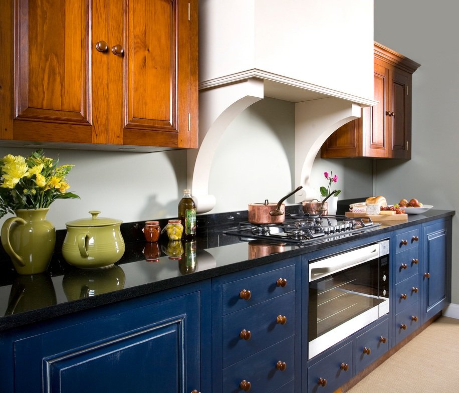 Характерное для английской кухни сочетание синего гарнитура, белых стен и теплого дерева в интерьере