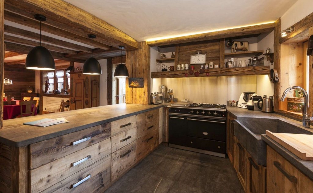 Кухня с массивным деревянным гарнитуром и винтажной печкой в лучших традициях Шале